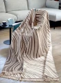 Dwustronny koc Cotton Cloud 150x200 cm z geometrycznym wzorem w kremowo-brązowej kolorystyce, bawełniany koc dekoracyjny z frędzlami na łóżko lub sofę.