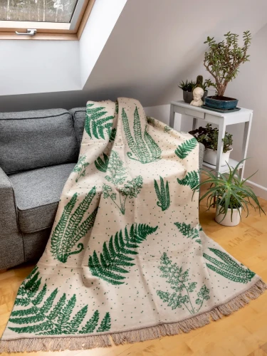 Dwustronny koc Cotton Cloud 150x200 cm z motywem liści w zielono-beżowej kolorystyce, bawełniany koc dekoracyjny z frędzlami na łóżko lub sofę.